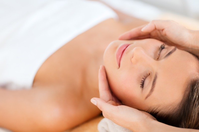 Entspannende Gesichtsbehandlung – Fresh Glow Facial Frau liegt entspannt während einer professionellen Gesichtsbehandlung in der Beauty-Praxis.